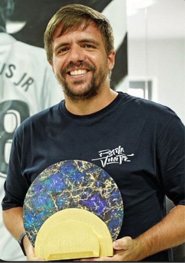 Camilo Coelho segurando uma peça artística